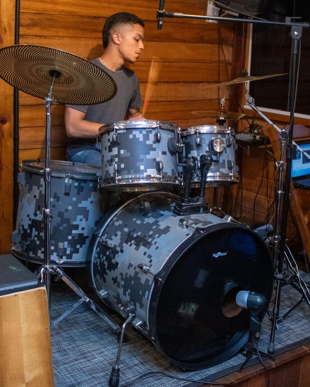 Aluno tocando bateria de perfil em sala tratada da Badrumtss